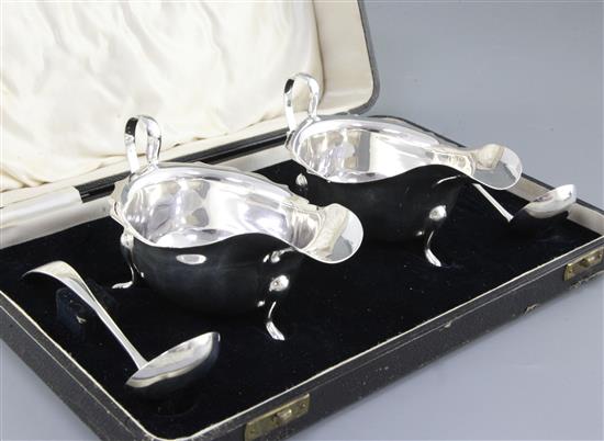 A cased pair of George V silver sauce boats and matching ladles, boat length 148mm, weight 8.8oz/276grms.
